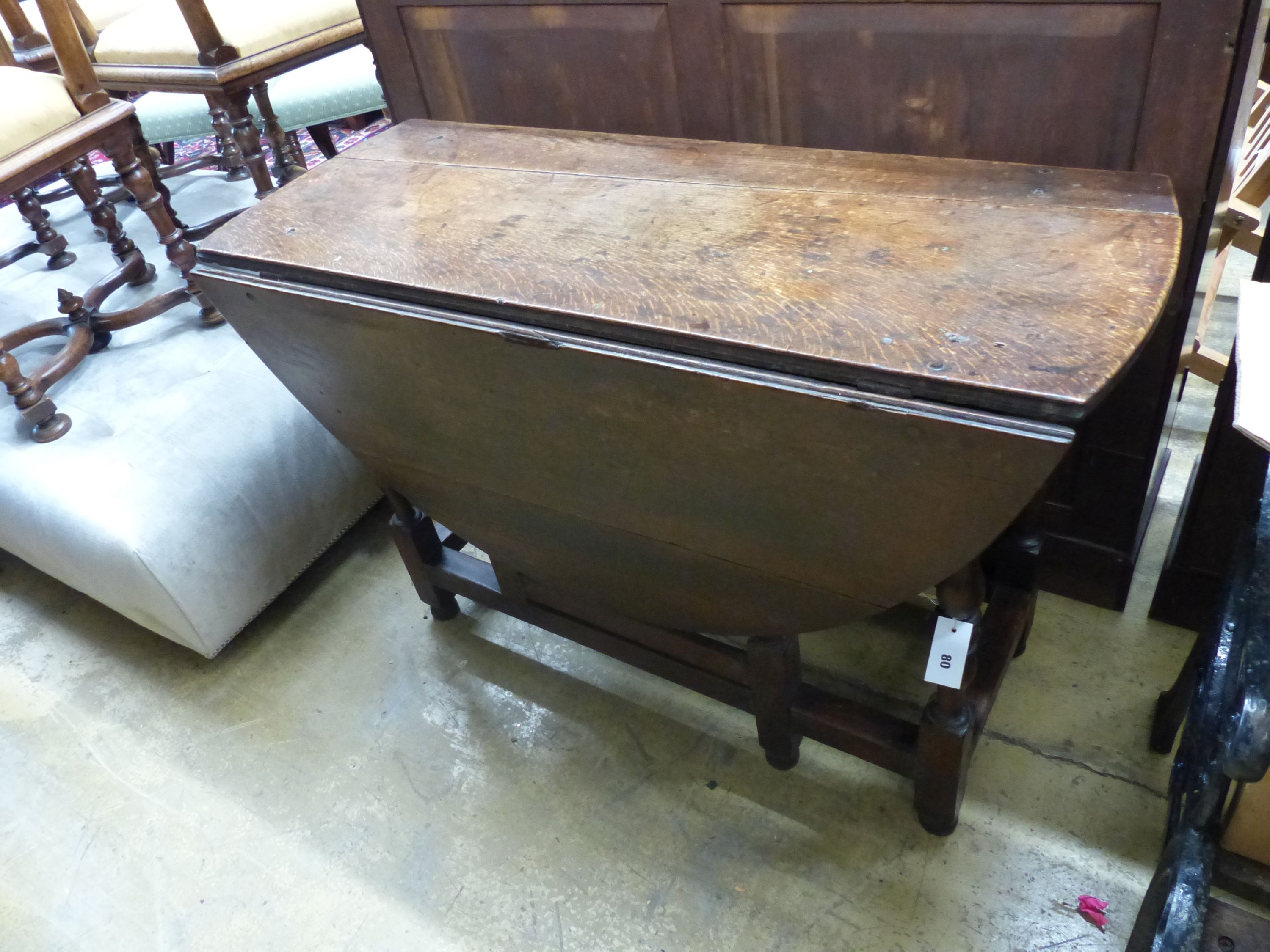 An 18th century oval oak gateleg dining table, length 135cm extended, width 114cm, height 75cm